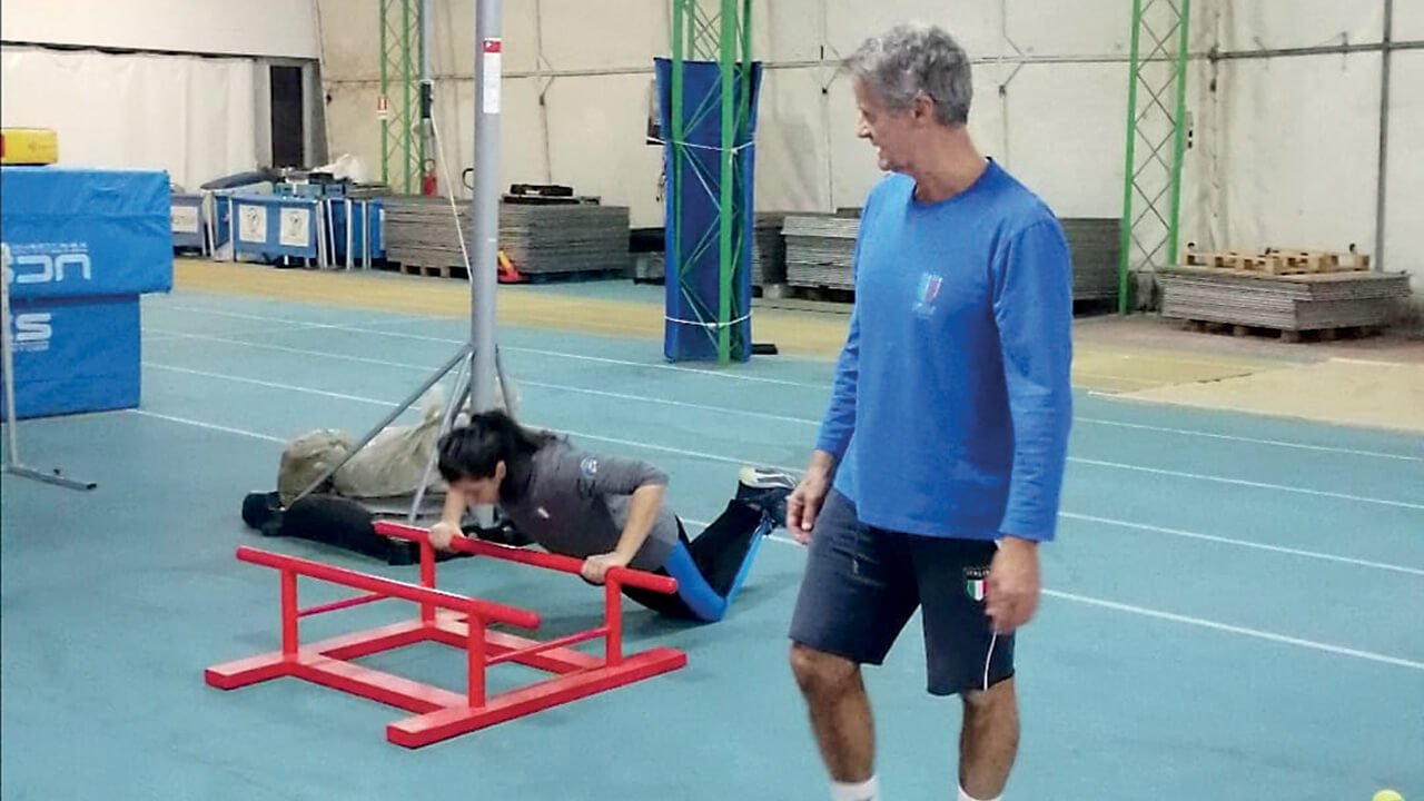 Il preparatore atletico delle squadre nazionali, Fabio Partigiani, e la tiratrice azzurra Federica Caporuscio: si esercita compiendo alcuni piegamenti alla sbarra. © Fitav